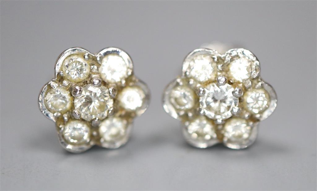 A pair of white metal and seven stone diamond set flower head cluster earrings, 8mm, gross 2.6 grams.